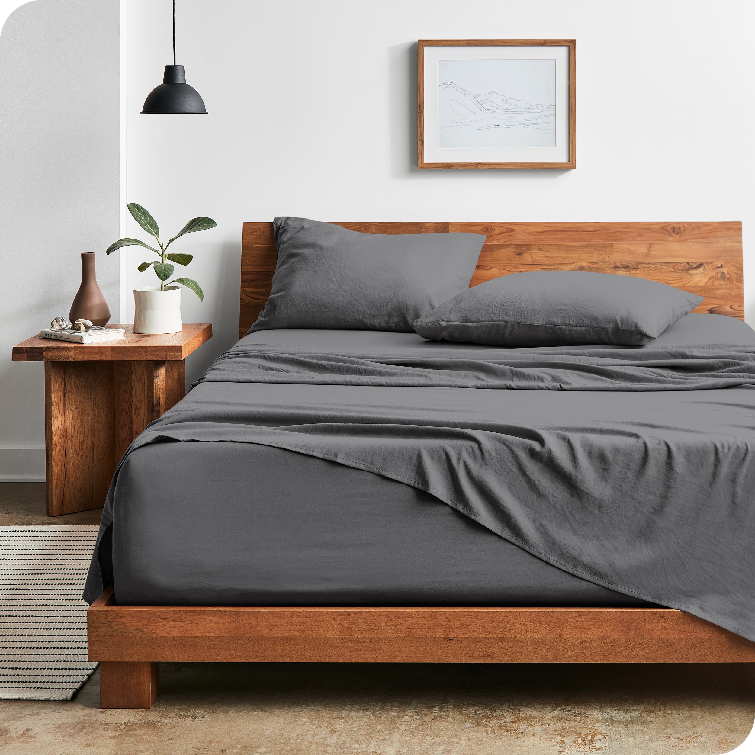 Modern bedroom with Sandwashed sheets draped over the end and side of mattress
