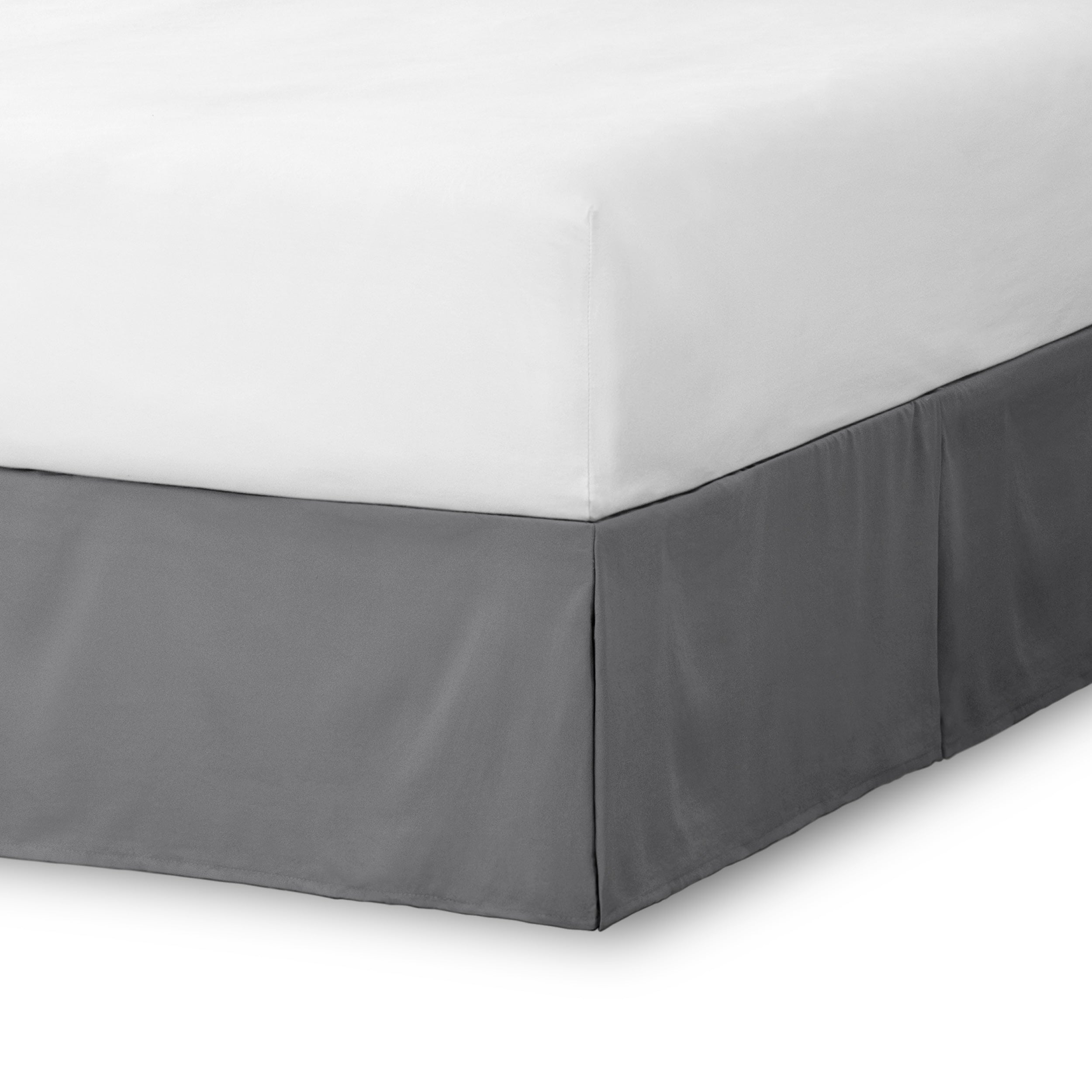 The corner of a bed skirt on a bed frame