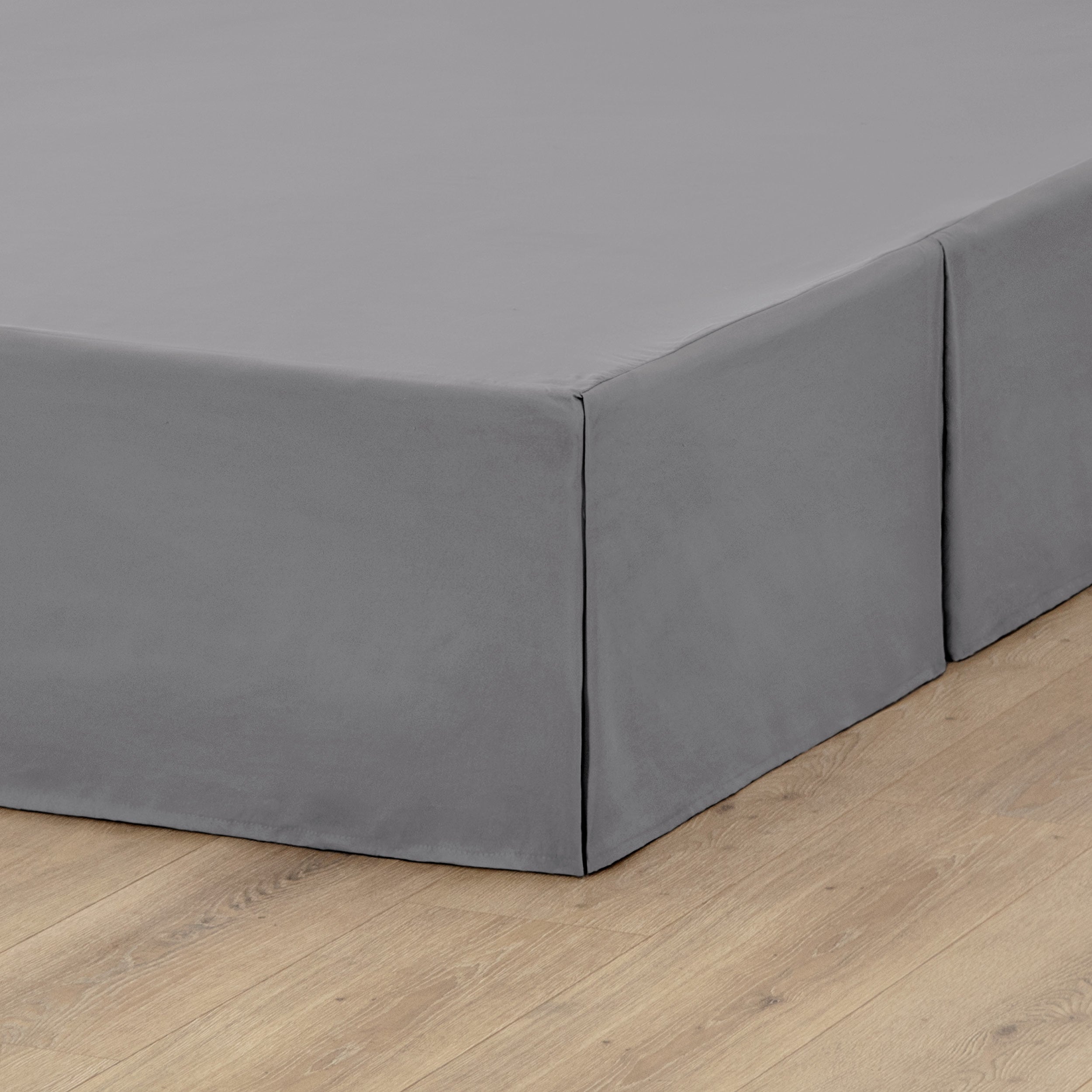 A box spring with a bed skirt on it