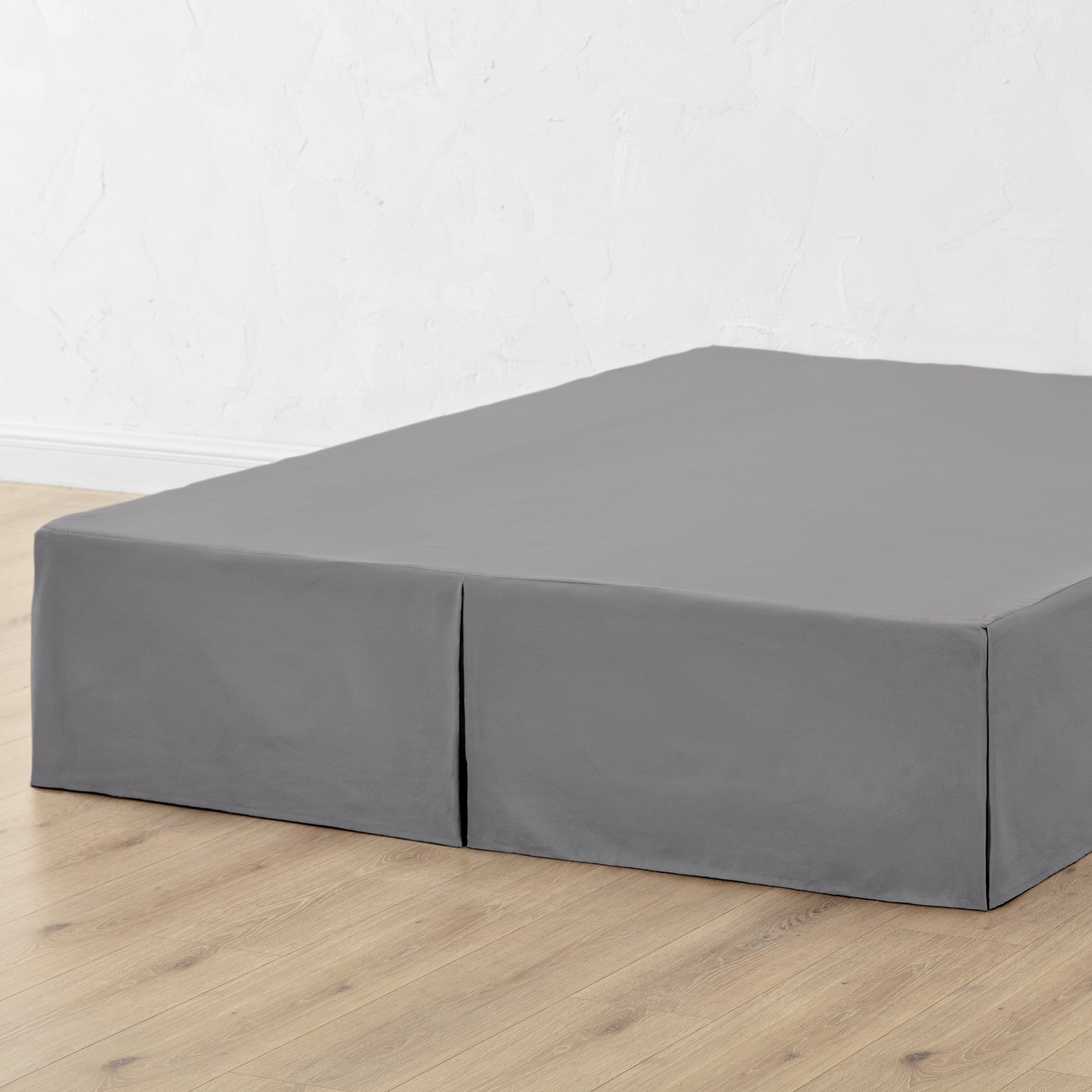 A bed skirt draped over a box spring