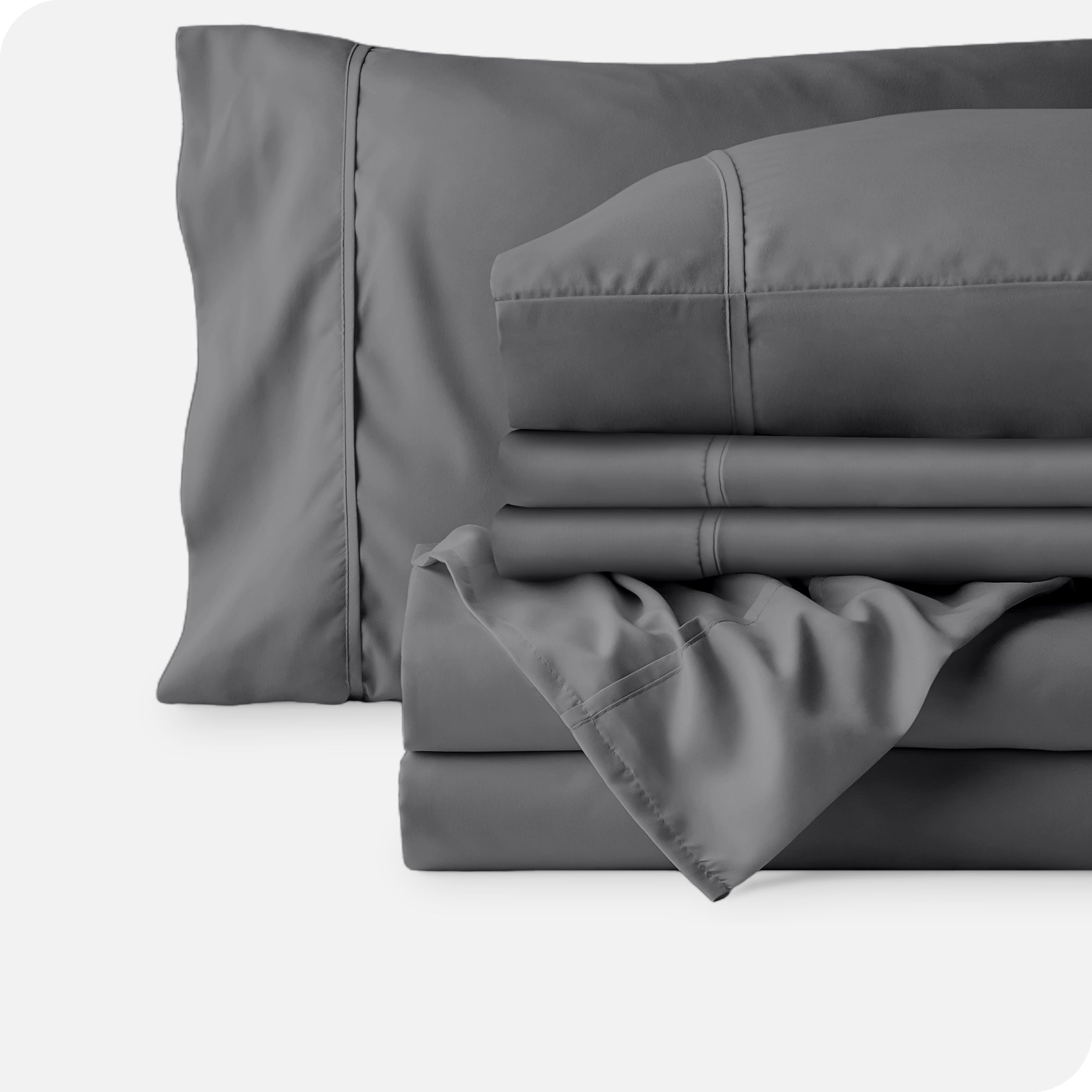 Microfiber sheets neatly folded with corner draped over, two folded pillowcases and two display pillows.
