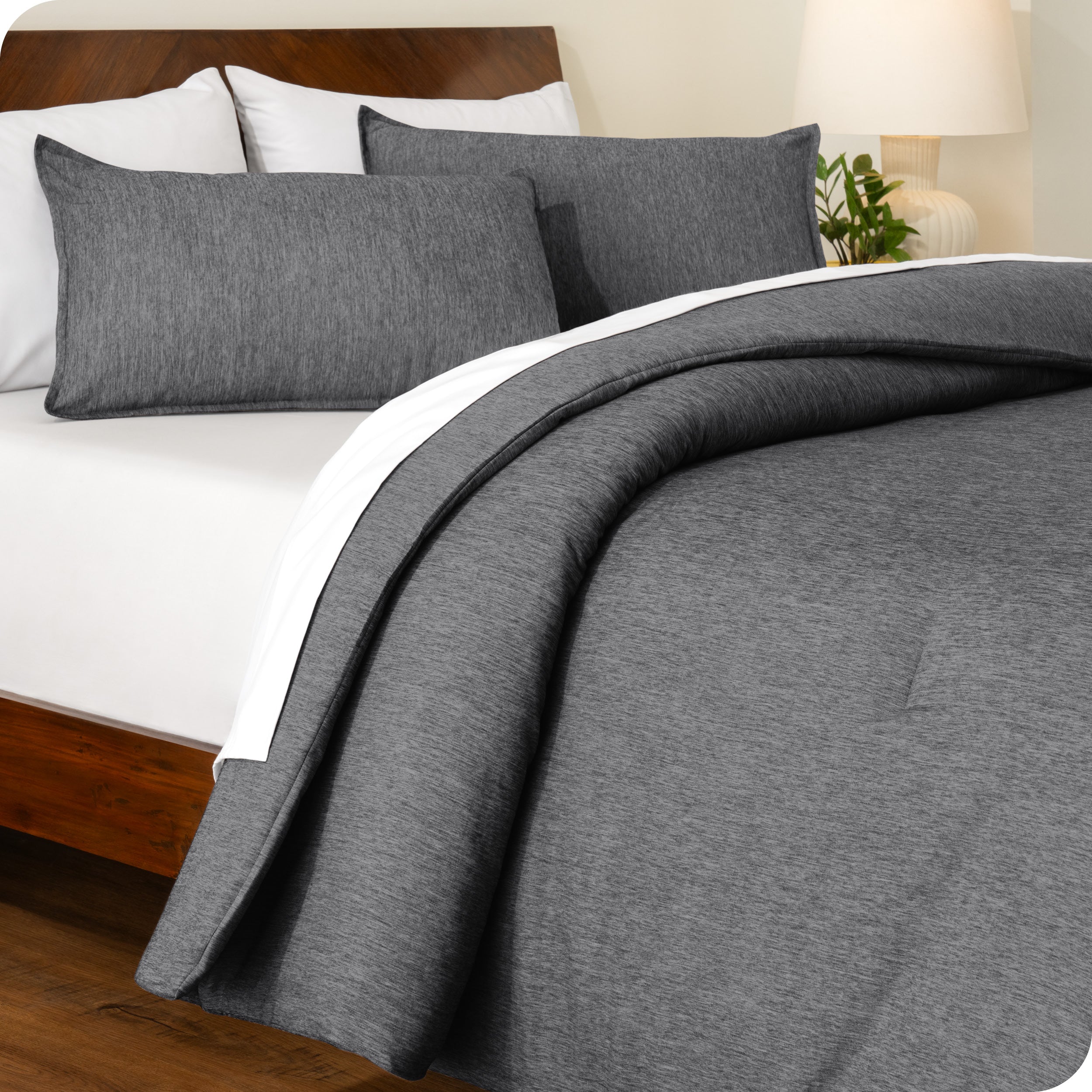 A side view of a modern bed with a comforter set and pillow shams on the bed

