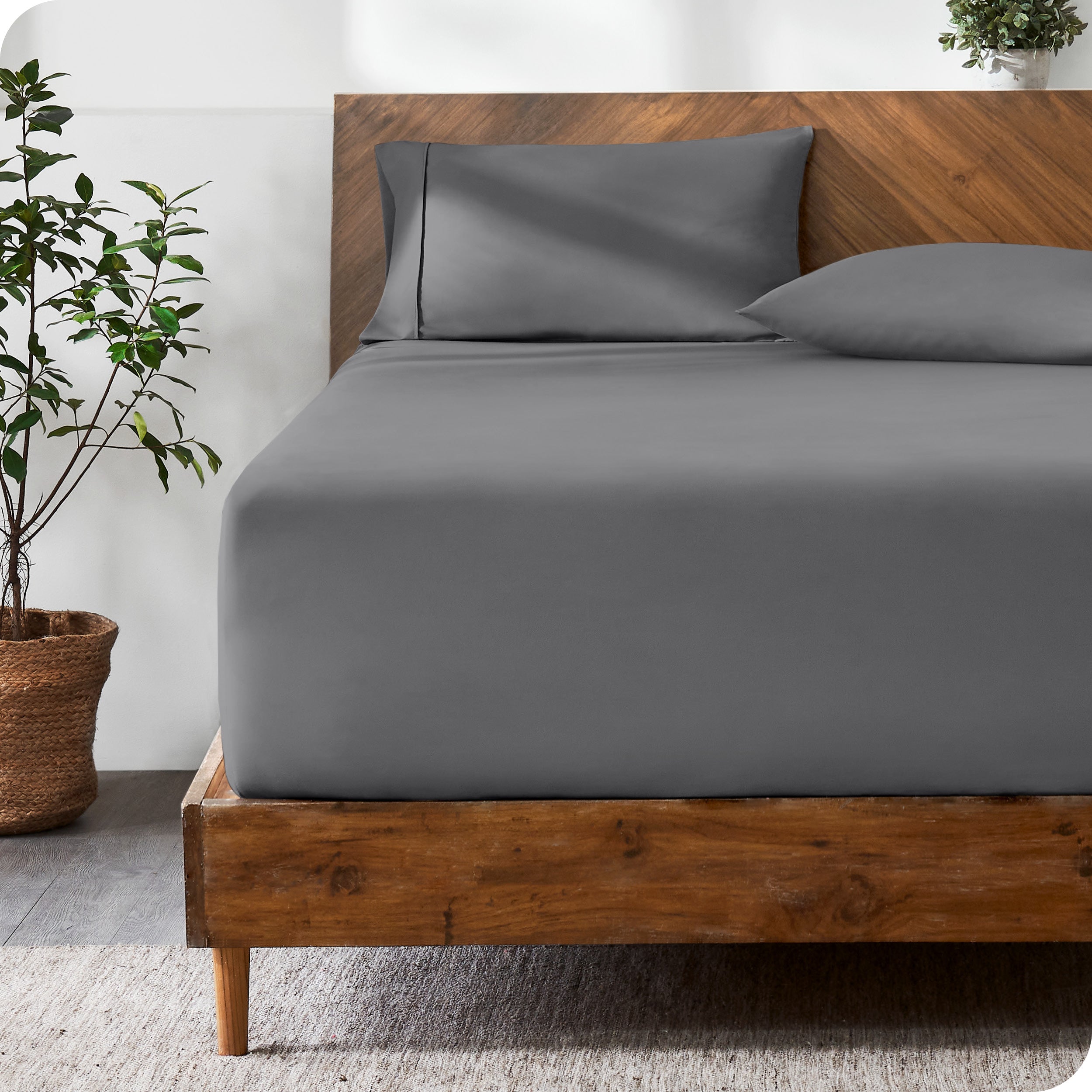 A modern bed with a fitted microfiber sheet made on the mattress. 