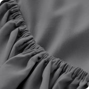 A close up of the elastic of a microfiber fitted sheet. 