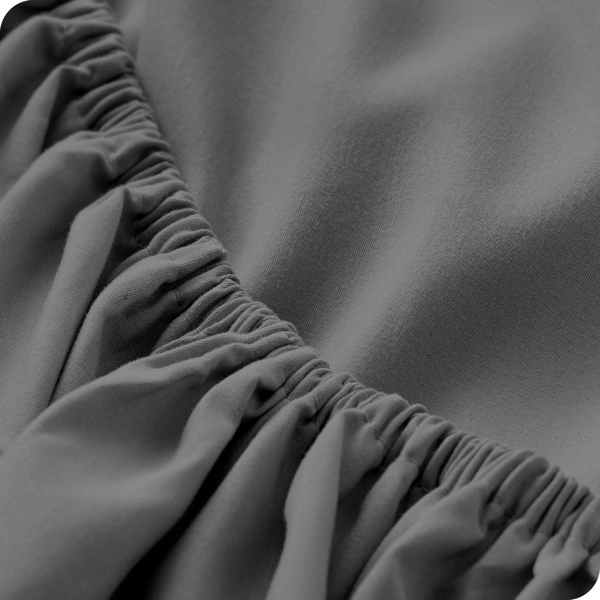 A close up of the elastic of a microfiber fitted sheet. 