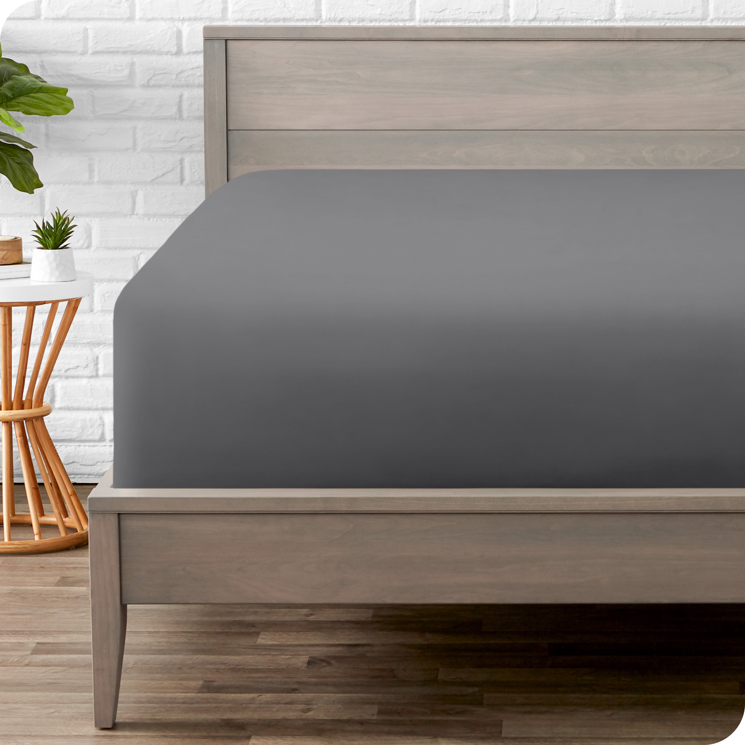 A modern bed with a fitted microfiber sheet on it