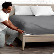 A man putting the microfiber fitted sheet on a mattress. 