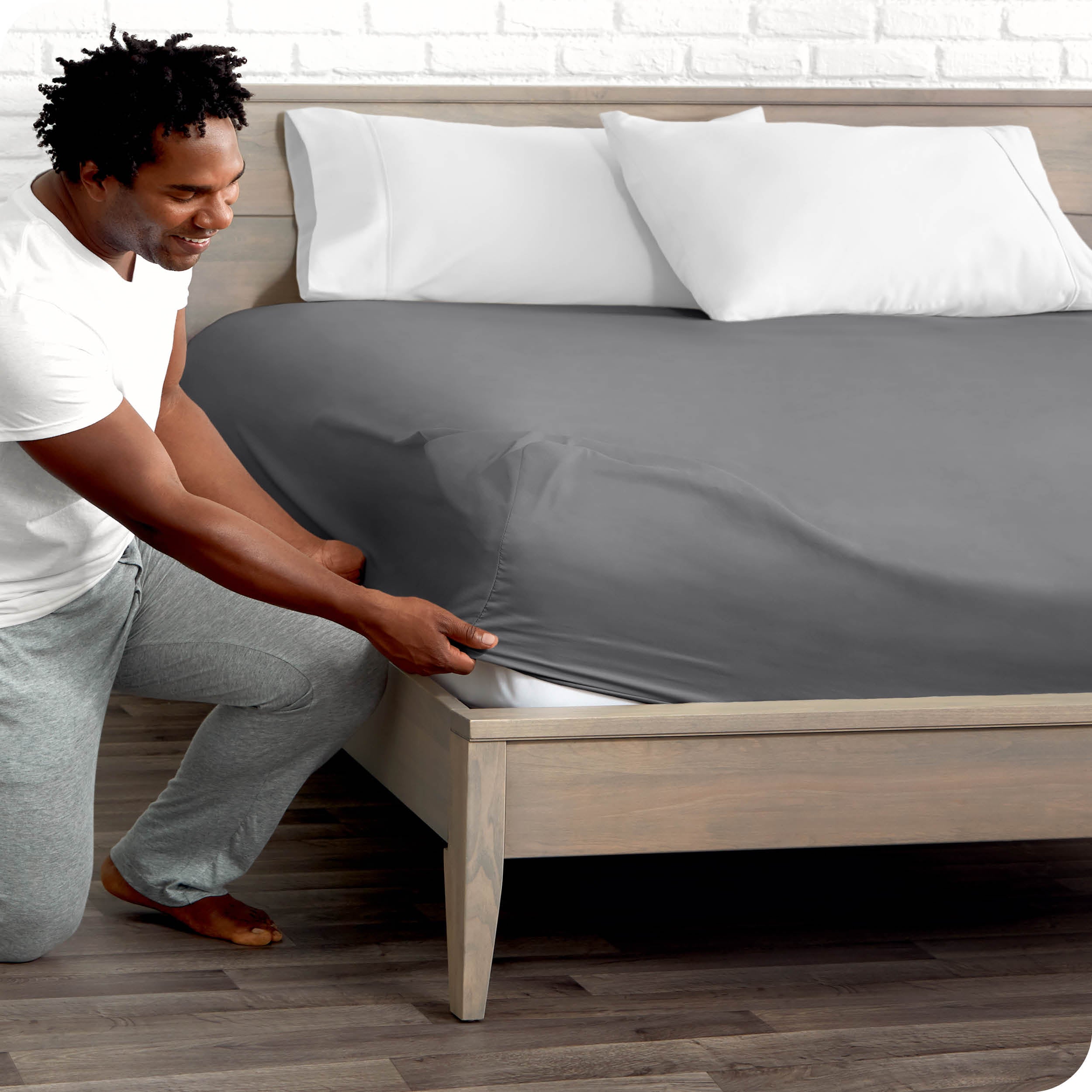 A man putting the microfiber fitted sheet on a mattress. 