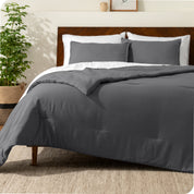 A comforter set on a bed with a dark wooden headboard