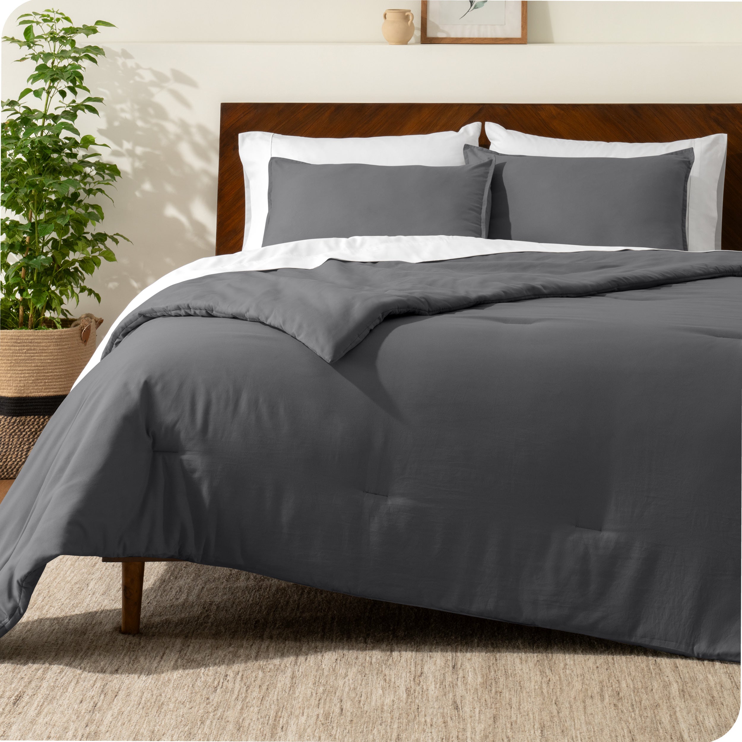 A comforter set on a bed with a dark wooden headboard