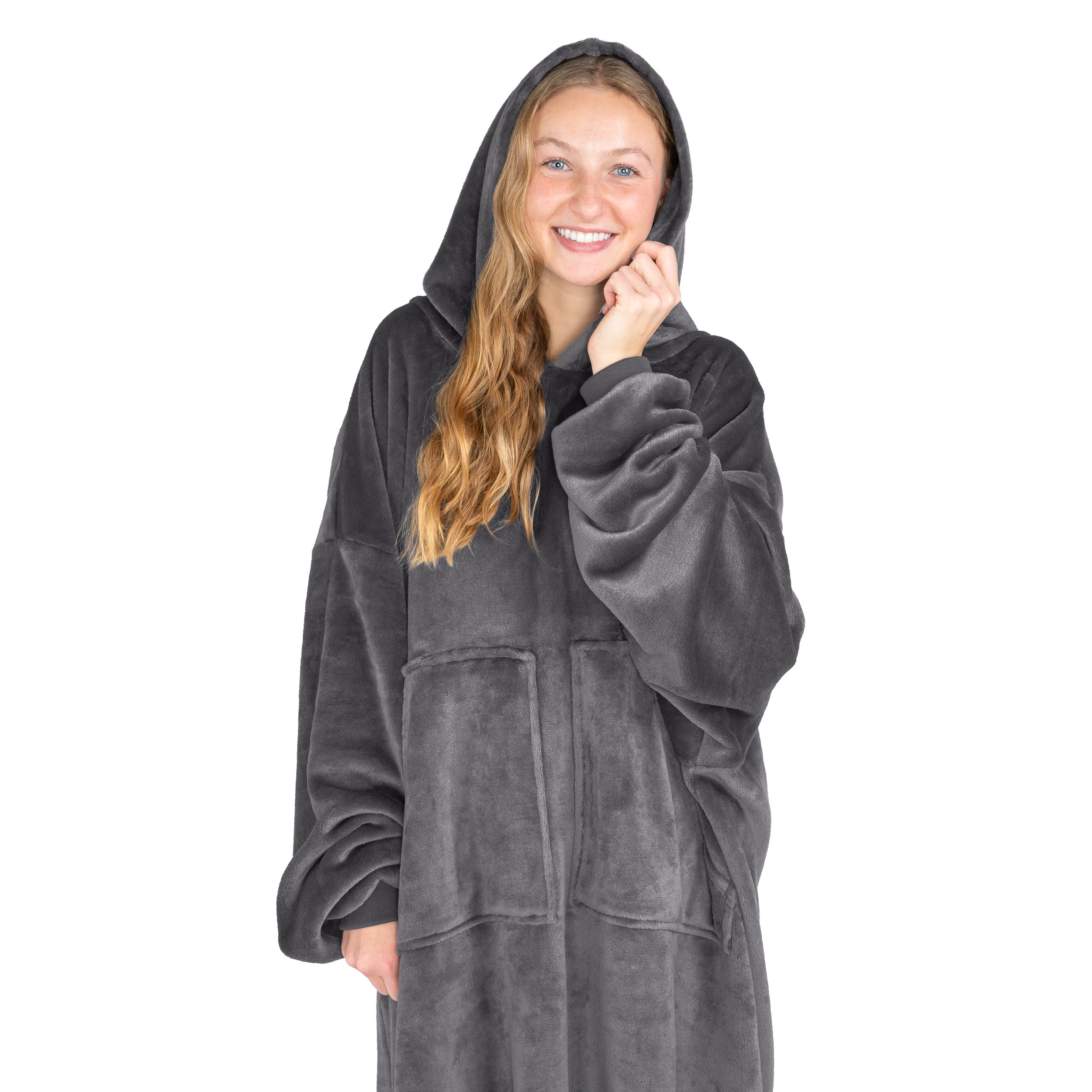 An adult is standing while wearing a microplush wearable blanket