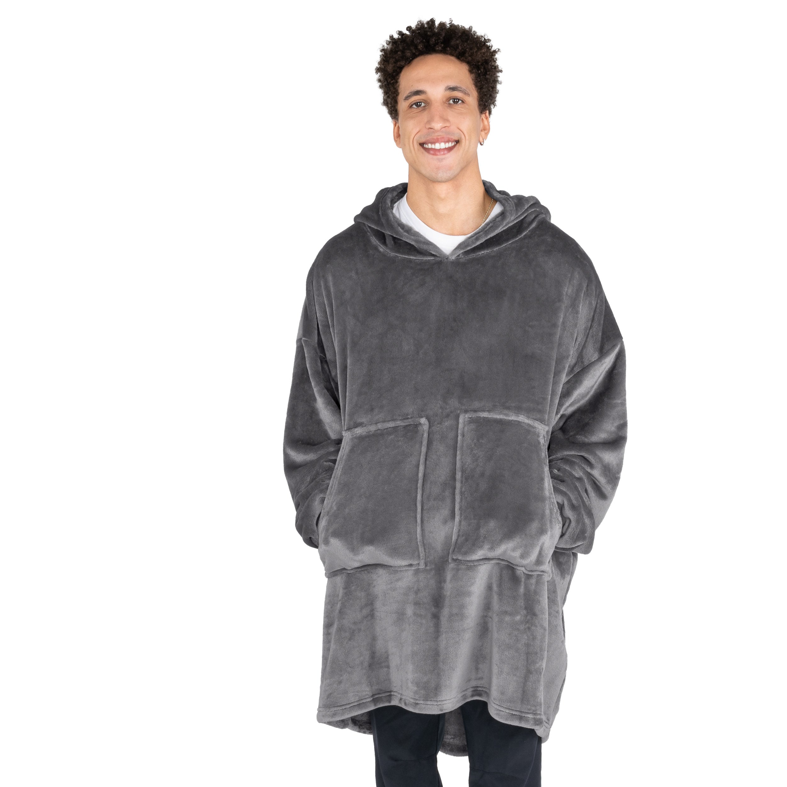 A man with his hands in the pockets of the wearable blanket he has on