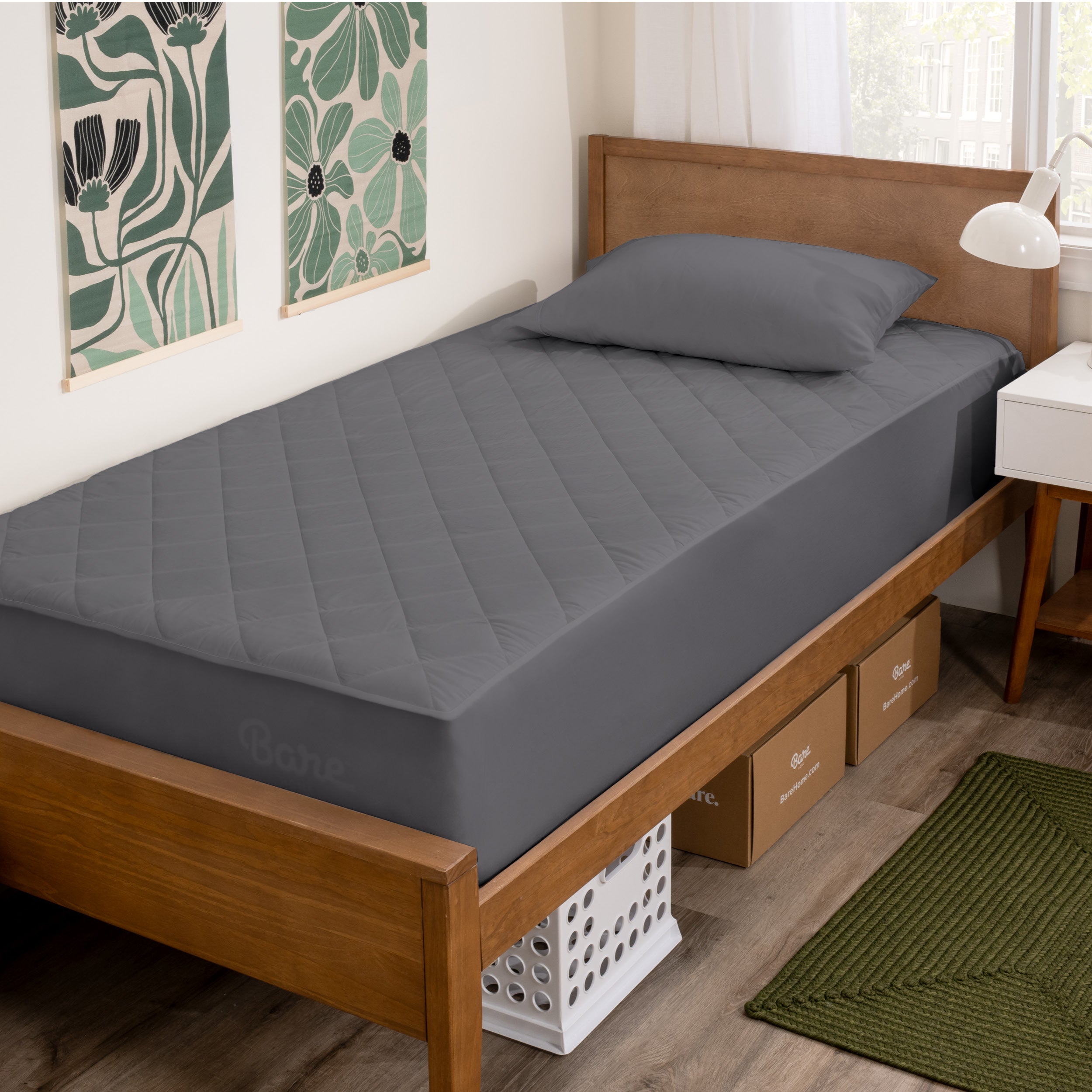 A bed with a wooden bed frame with a quilted mattress pad on.