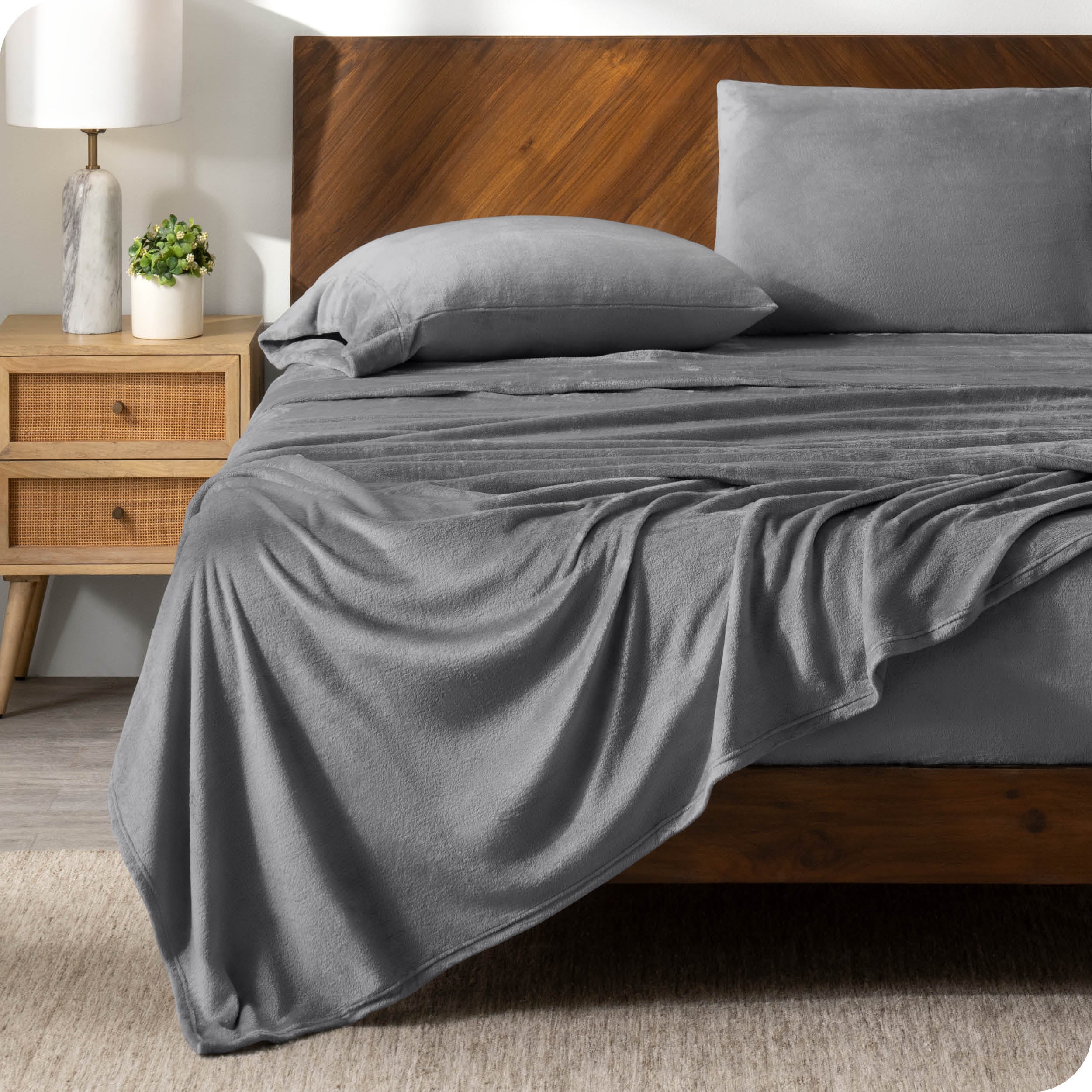 A grey sheet set on a bed with a wooden bed frame