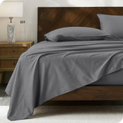 Percale sheet set on a bed with a wooden headboard