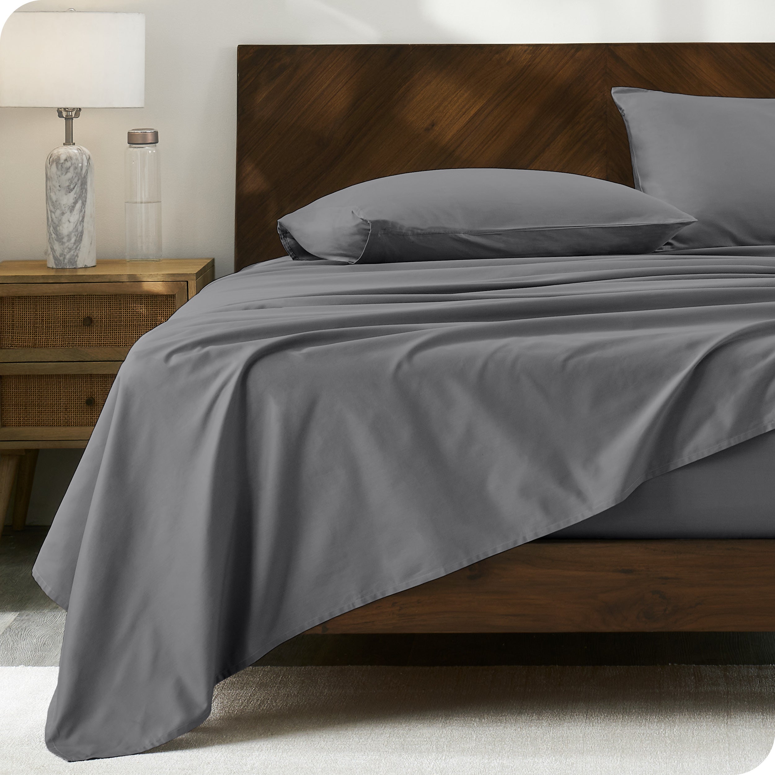 Percale sheet set on a bed with a wooden headboard