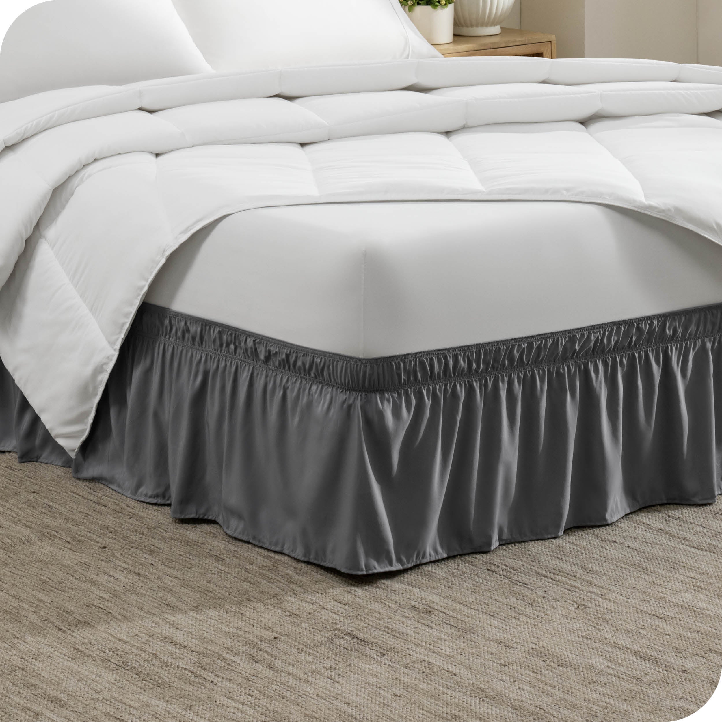The corner of a bed with a polyester bed skirt on it