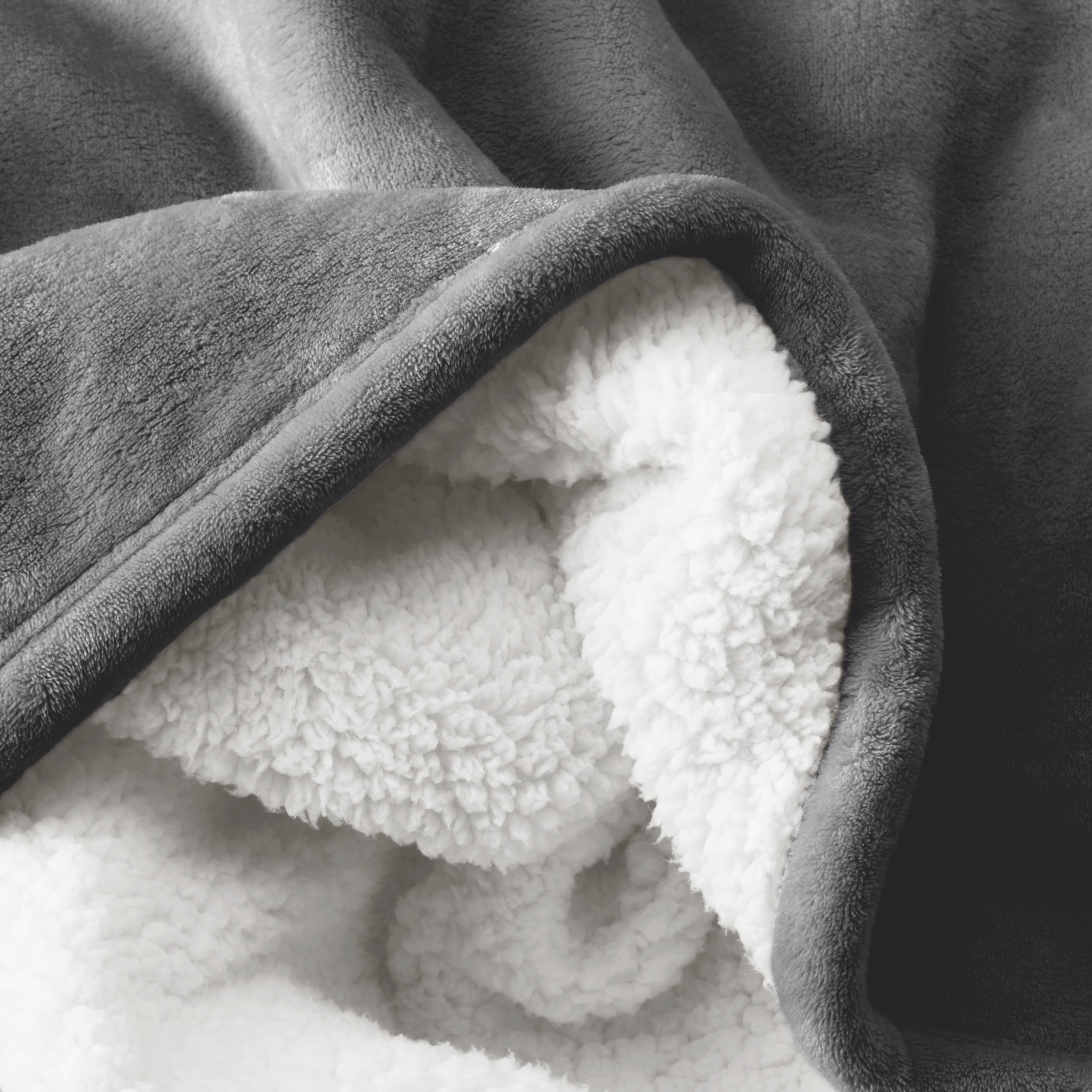 Close up of sherpa blanket showing texture of velvety soft side and sherpa backing