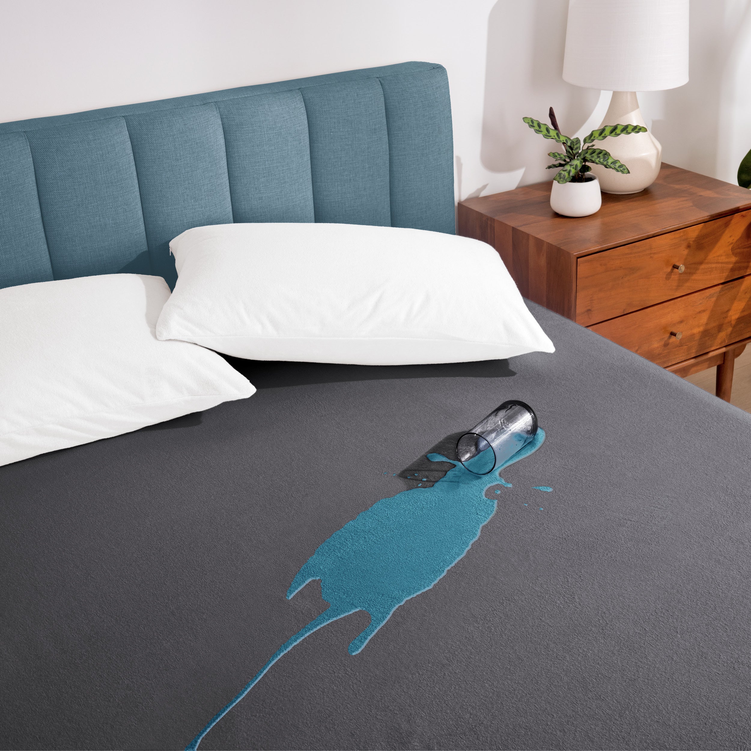 A glass of water spilled on a mattress protector
