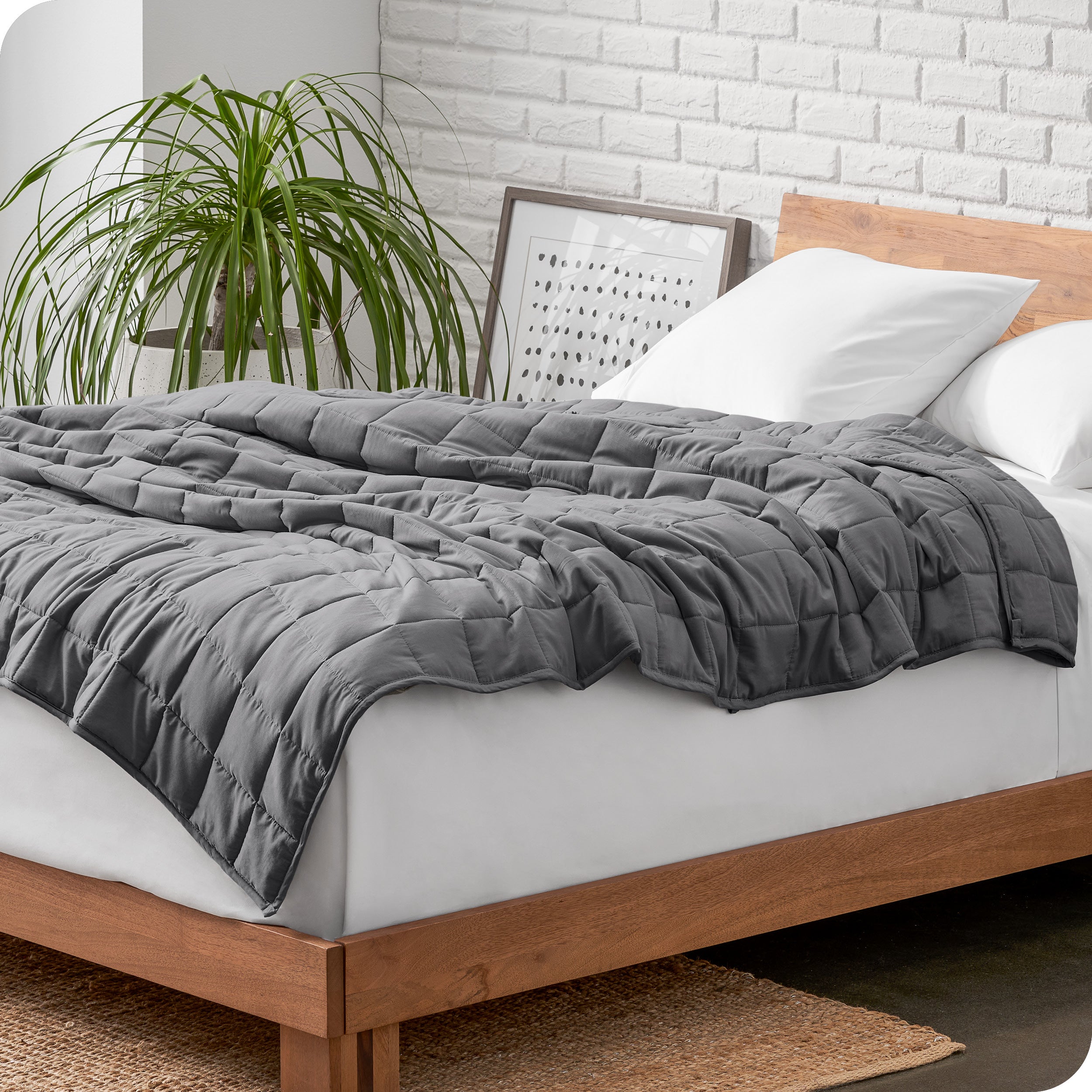 A cotton weighted blanket is loosely draped over a bed