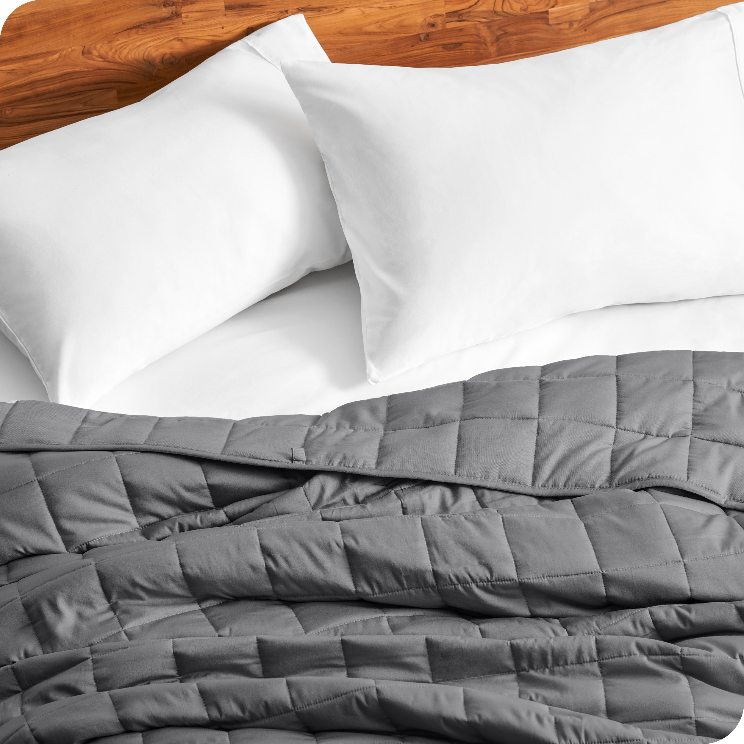 Close up of a weighted blanket on a bed with  2 pillows
