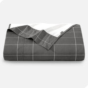 Neatly folded printed microfiber flat sheet with corner folded over. 