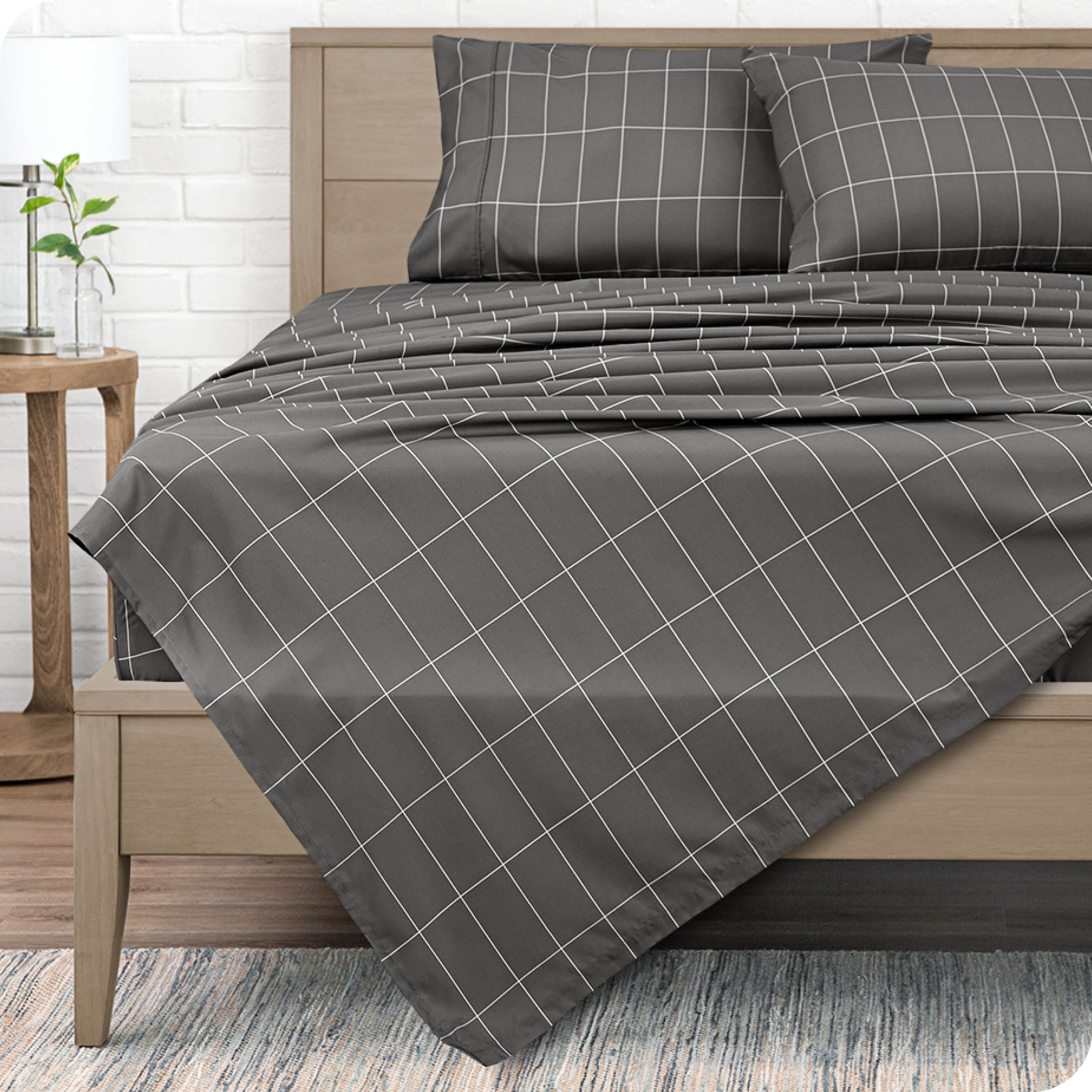 View from end of a modern bed with microfiber flat sheet draped over. 