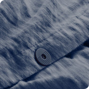 A close up of the flannel duvet cover showing the button, lining, texture, and pattern.