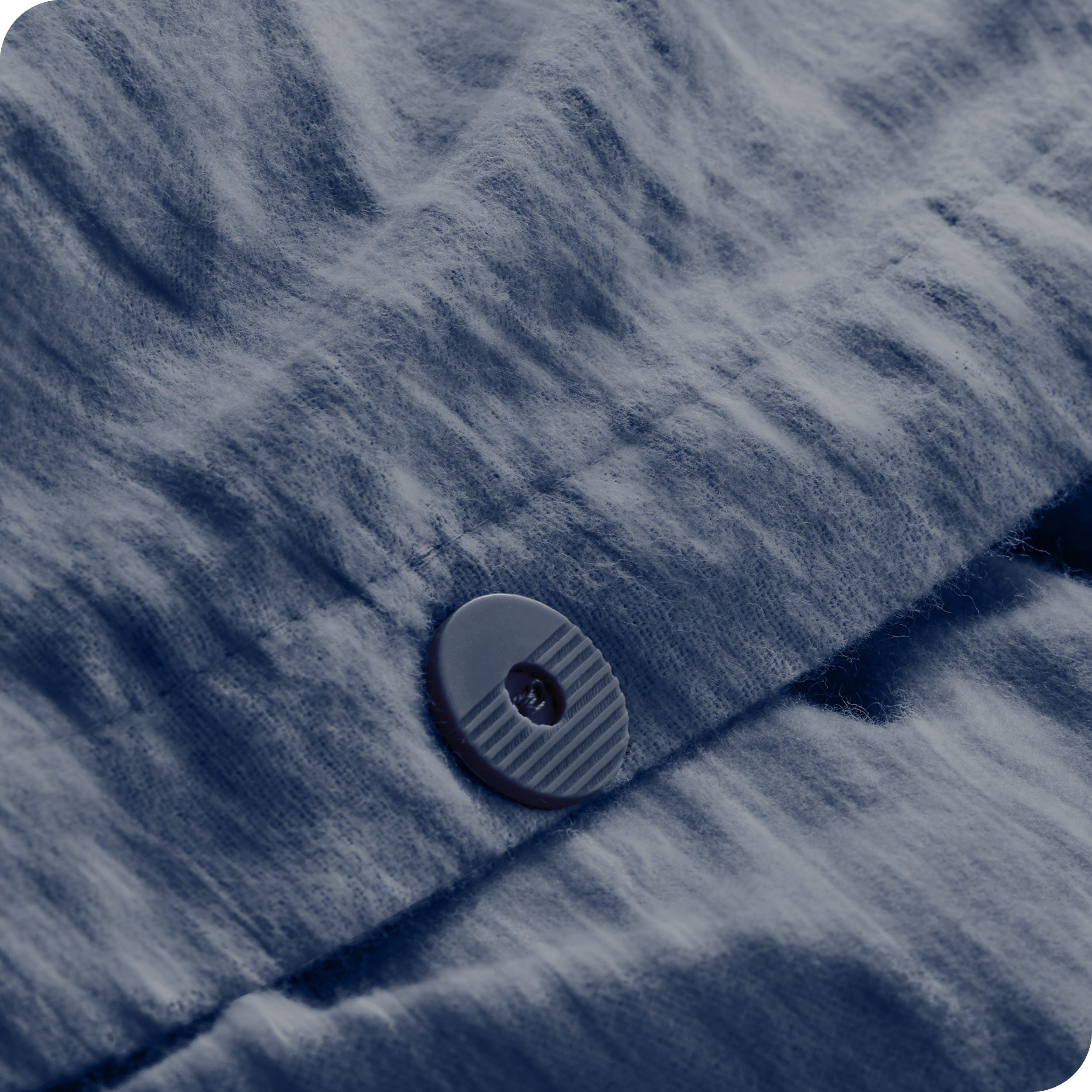 A close up of the flannel duvet cover showing the button, lining, texture, and pattern.