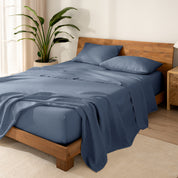 Wooden bed frame with  linen sheets on the mattress