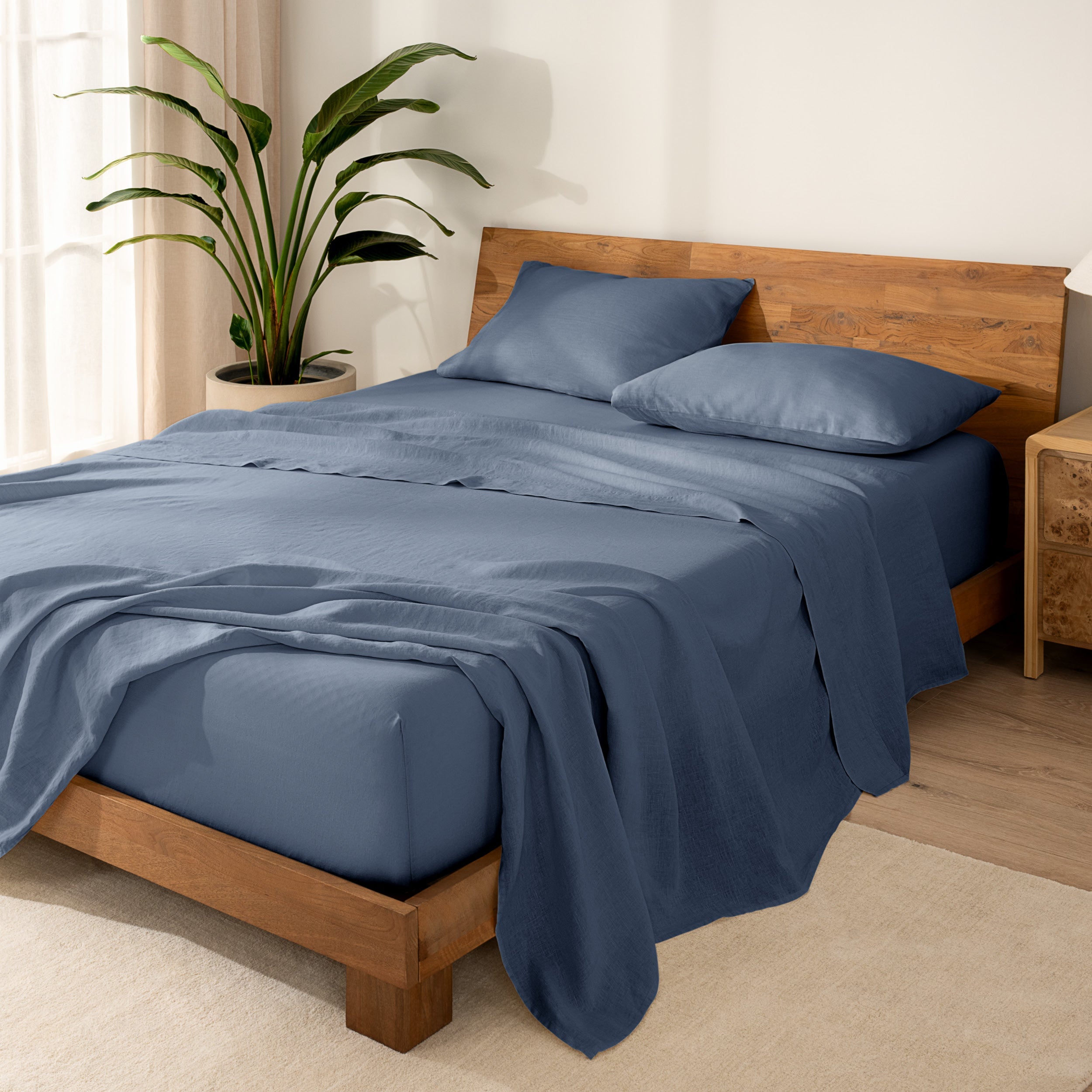Wooden bed frame with  linen sheets on the mattress