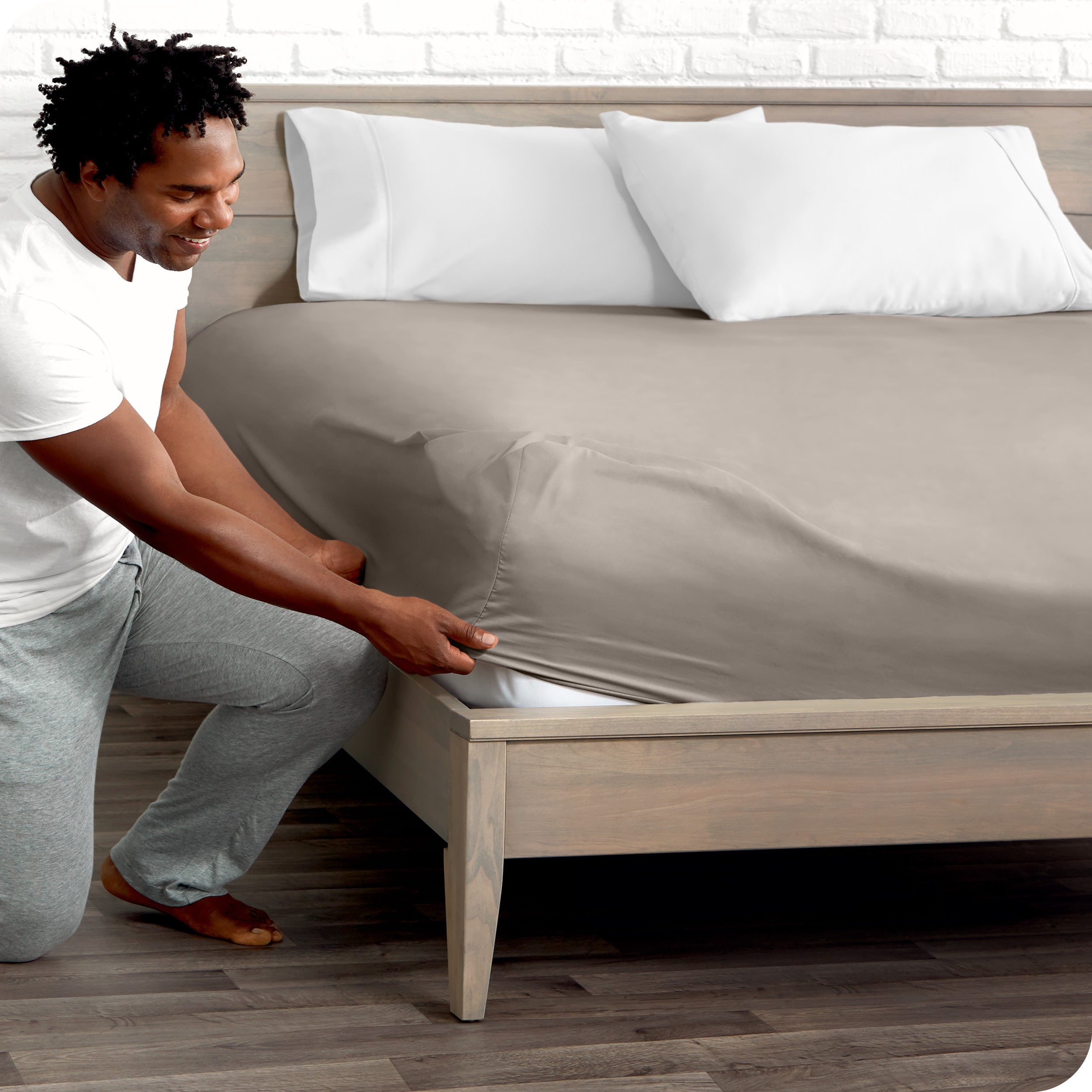 A man putting the microfiber fitted sheet on a mattress. 