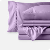 Microfiber sheets neatly folded with corner draped over, two folded pillowcases and two display pillows.