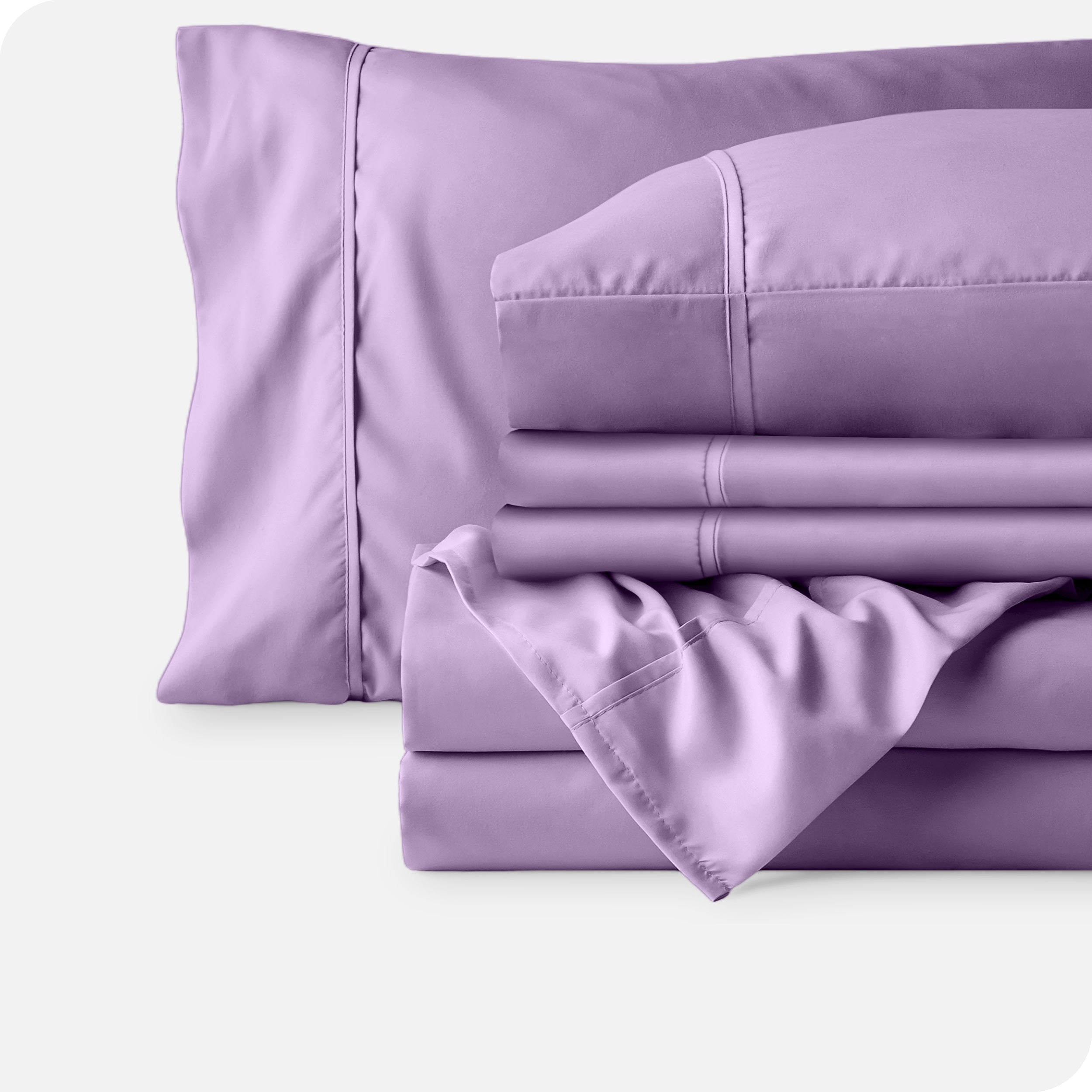 Microfiber sheets neatly folded with corner draped over, two folded pillowcases and two display pillows.
