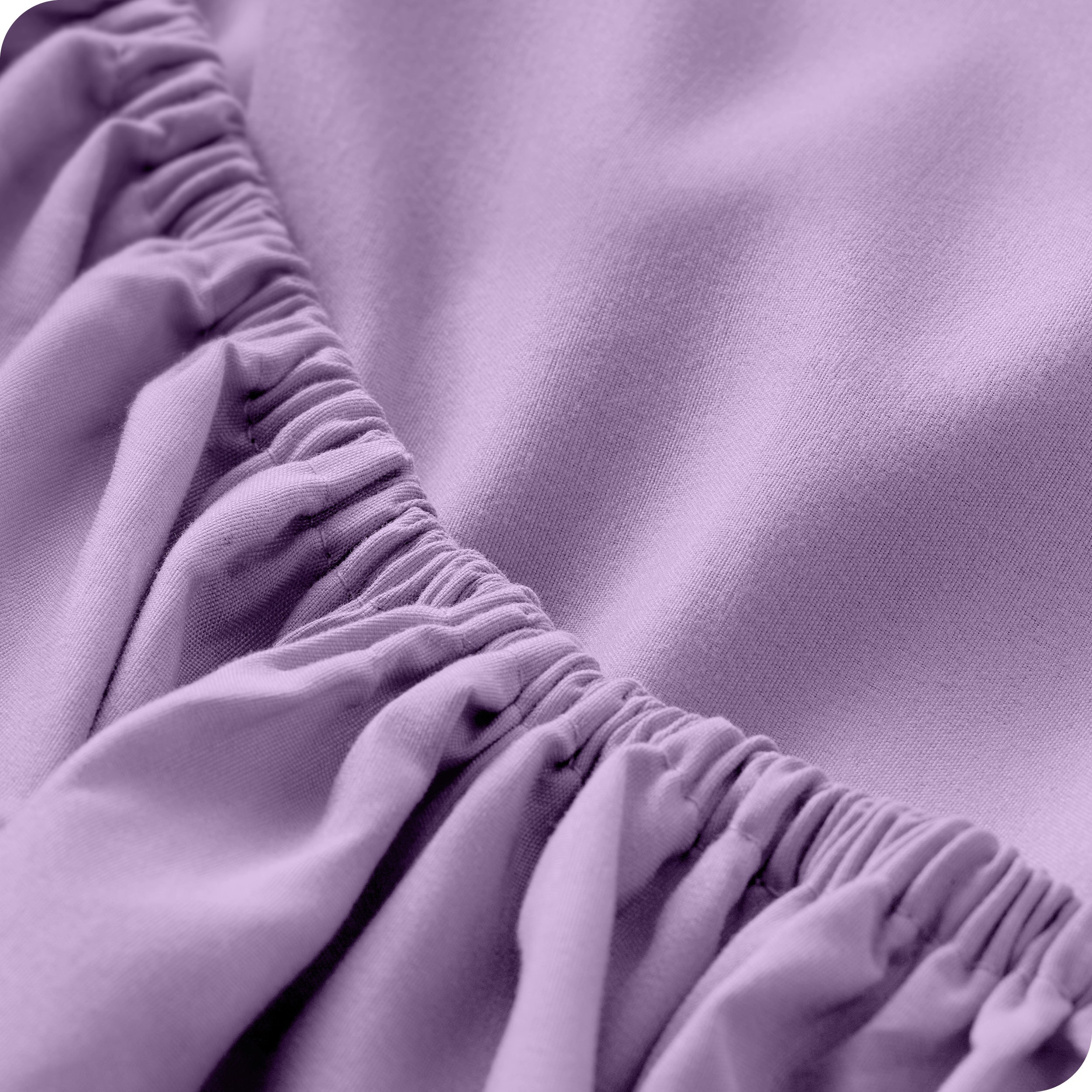 A modern bed with a fitted microfiber sheet on it