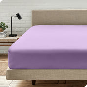 A bed with a microfiber fitted sheet on the mattress. 