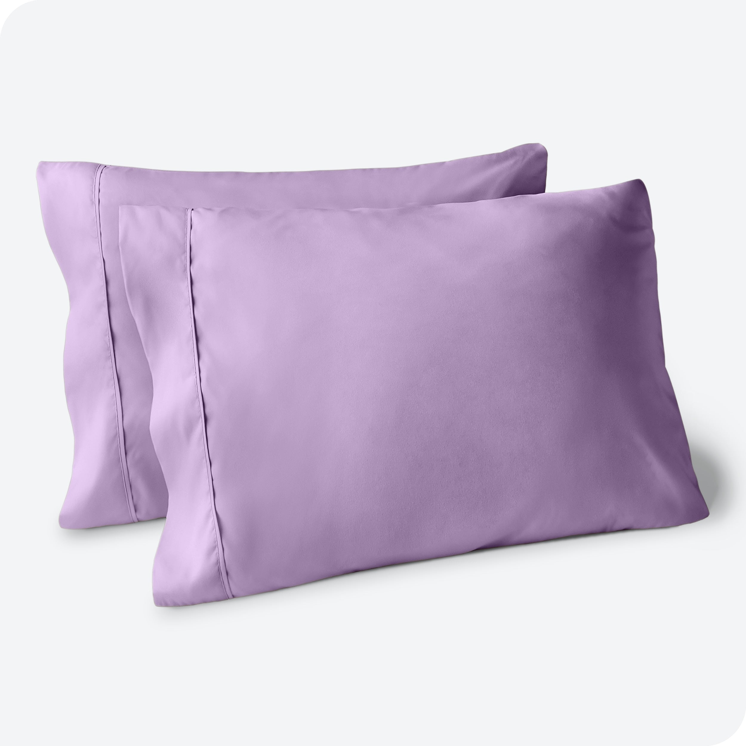Two pillows on a white background with blue pillowcases on them