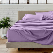 Microfiber sheets on a bed with a brick wall behind it