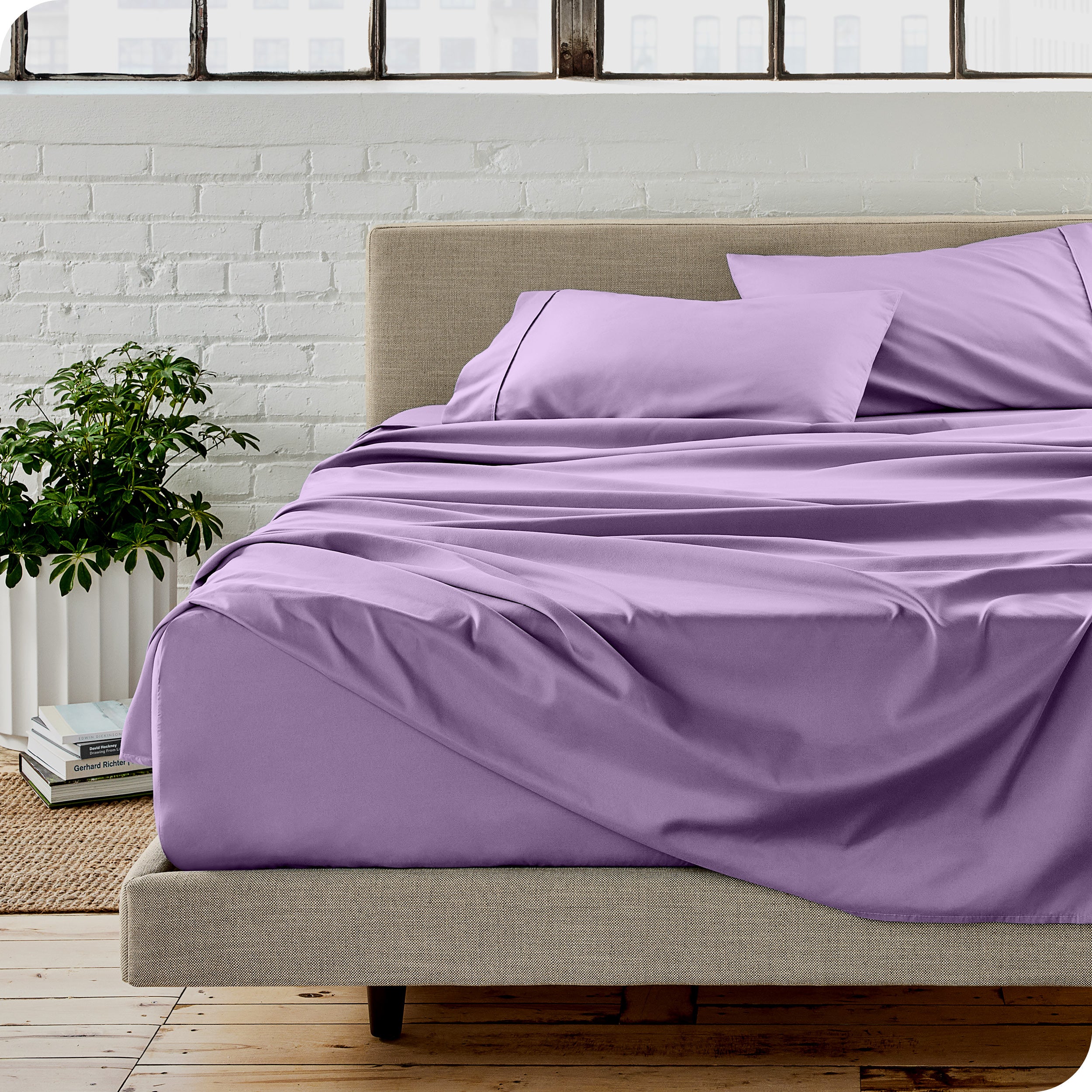 Microfiber sheets on a bed with a brick wall behind it