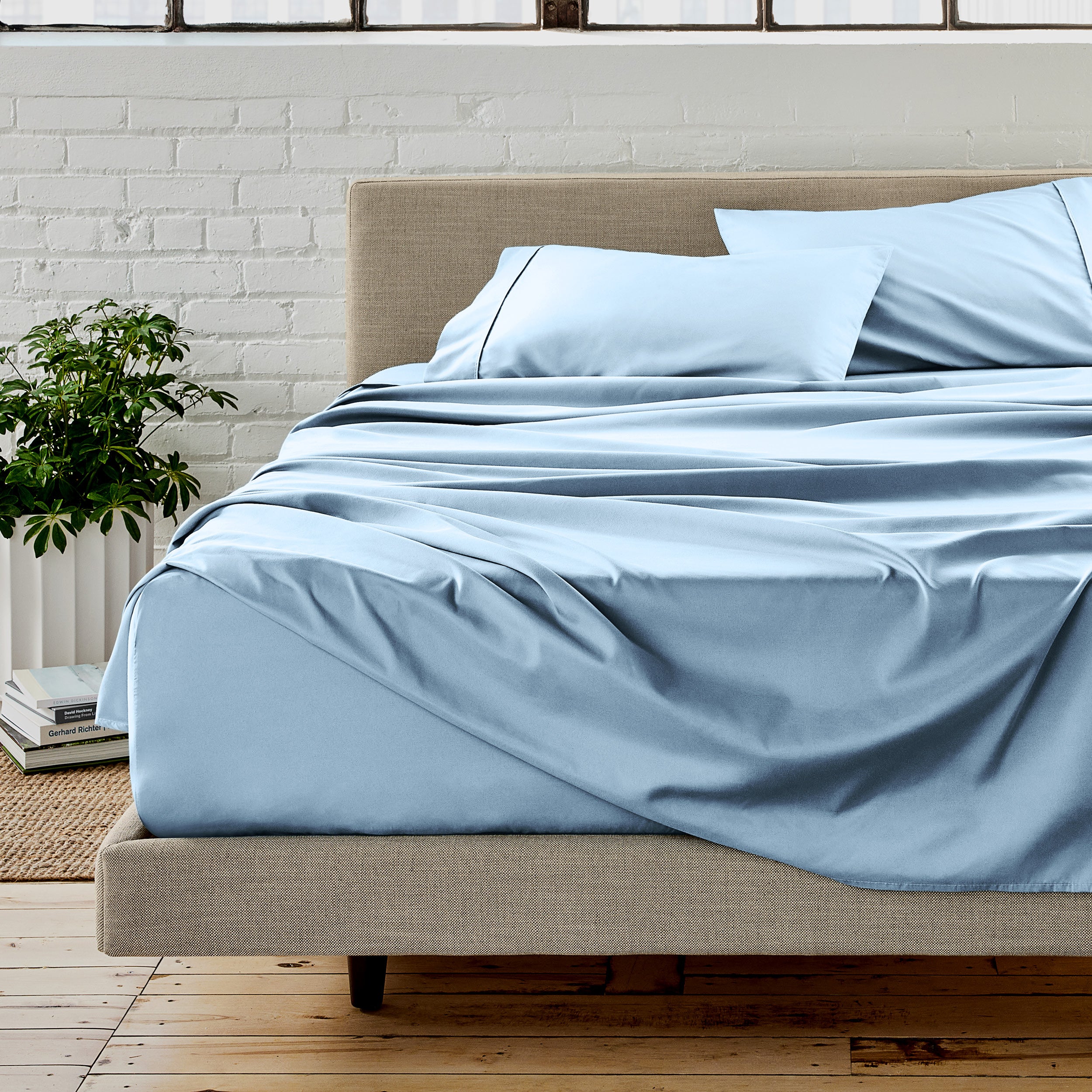 Microfiber sheet set on a bed with a white brick wall in the background
