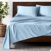 Wooden bed frame with bamboo sheets on the bed