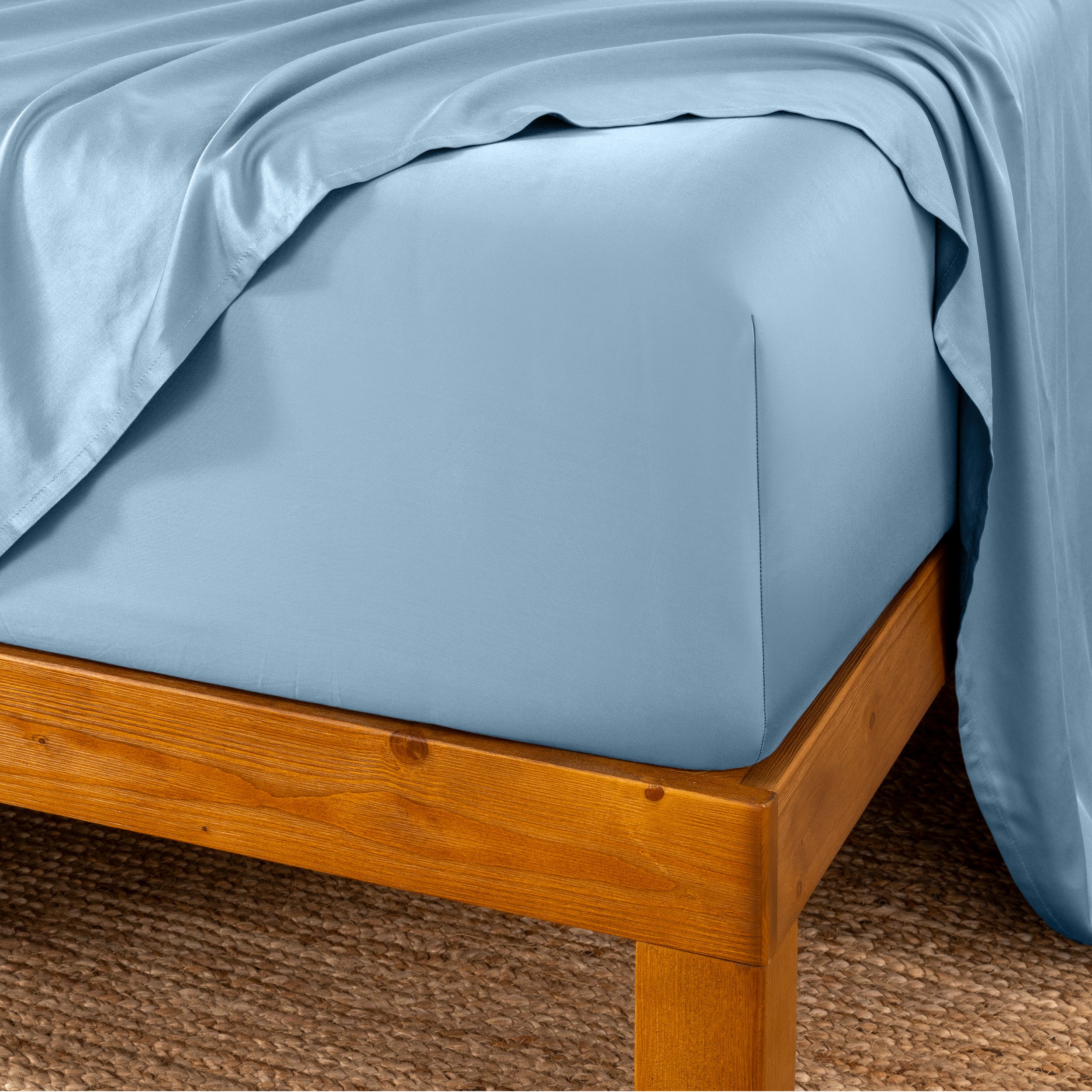Bed sheets on a wooden bed frame with a brown carpet background