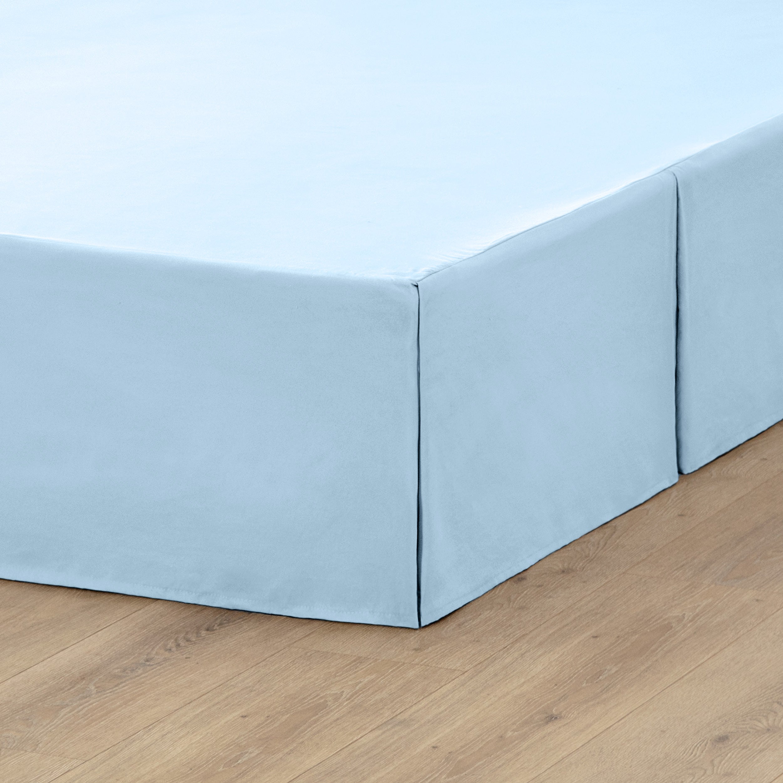 A box spring with a bed skirt on it