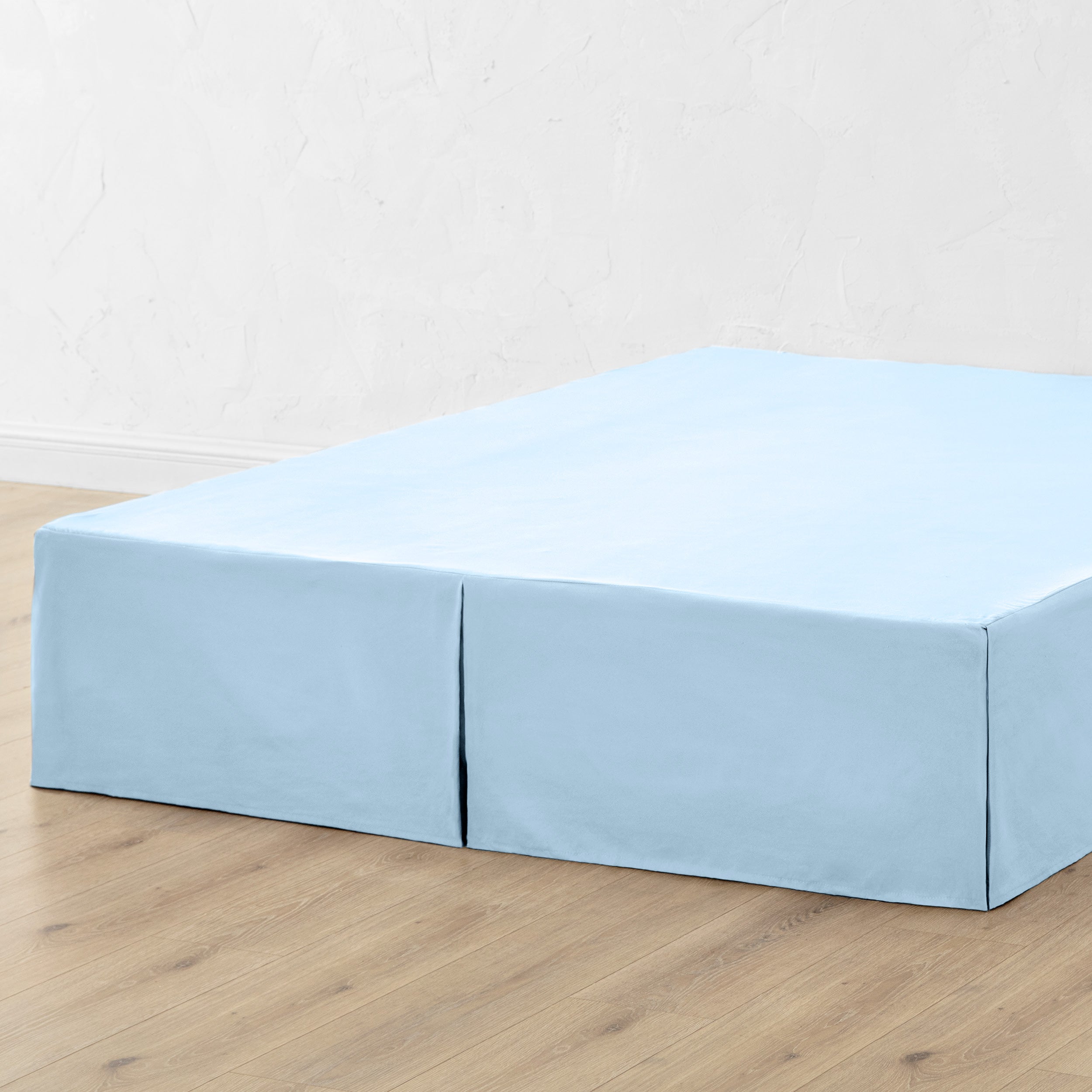 A bed skirt draped over a box spring