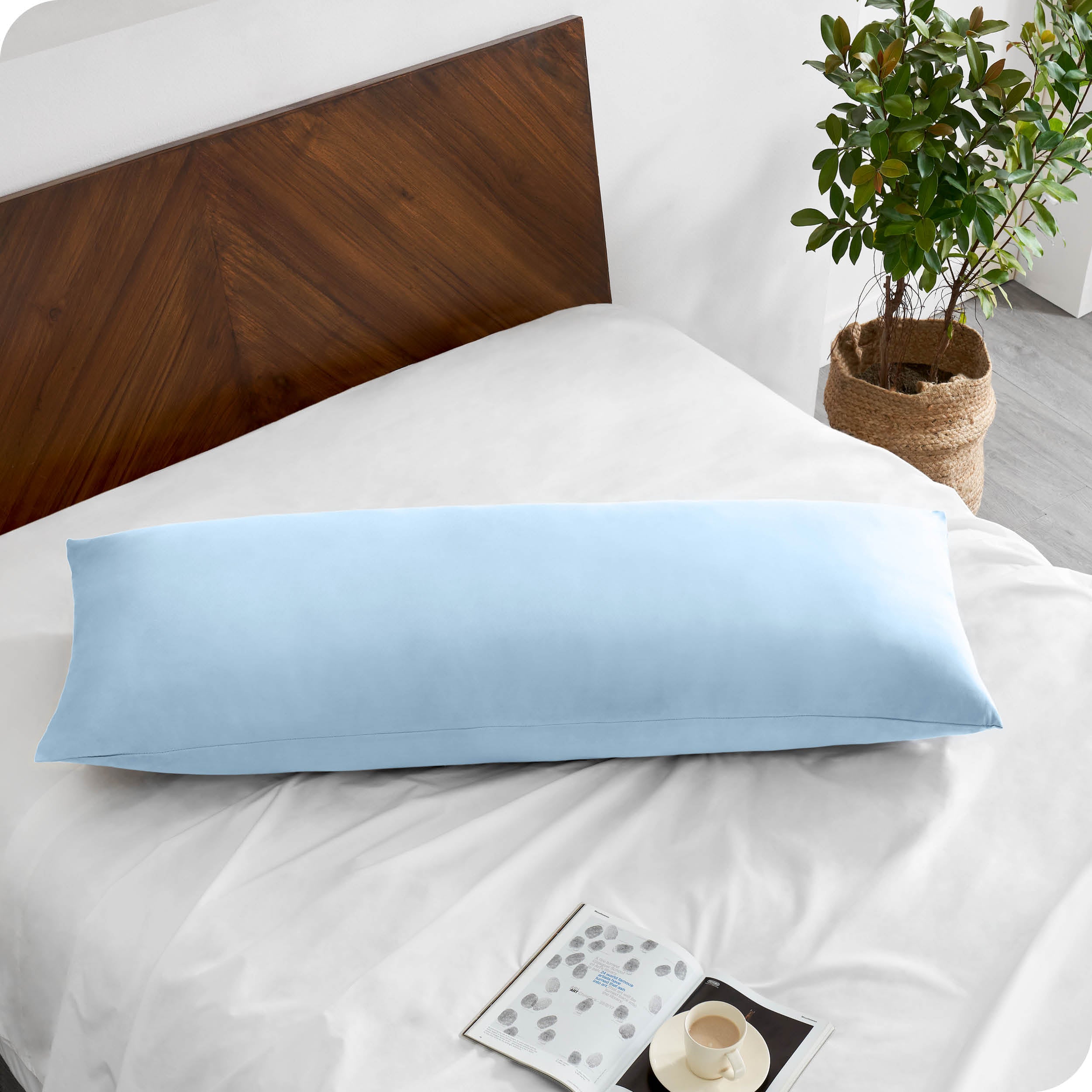 A body pillowcase on a pillow on a bed with all white bedding