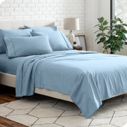 A bedroom setting with a bed made with the microfiber bed sheets and four pillows.
