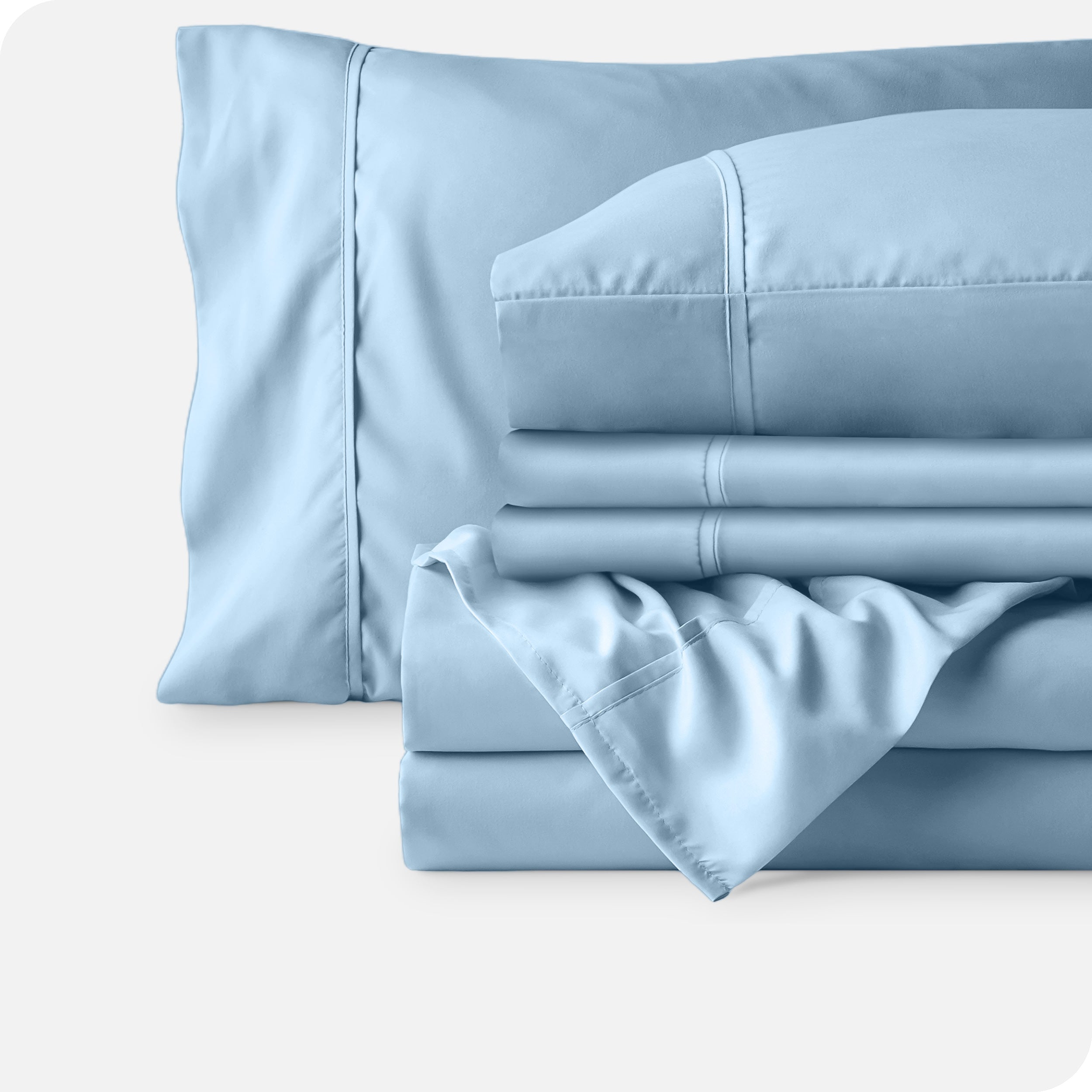 Microfiber sheets neatly folded with corner draped over, two folded pillowcases and two display pillows.