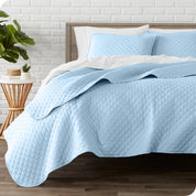 A quilted coverlet set on a bed