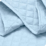 Close up of a coverlet showing the stitching