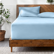 A modern bed with a fitted microfiber sheet made on the mattress. 